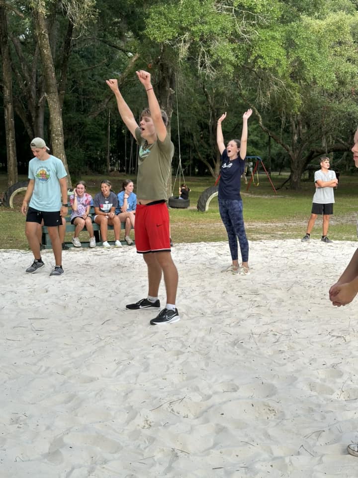 Campers celebrating on the volleyball court at Florida Bible Camp