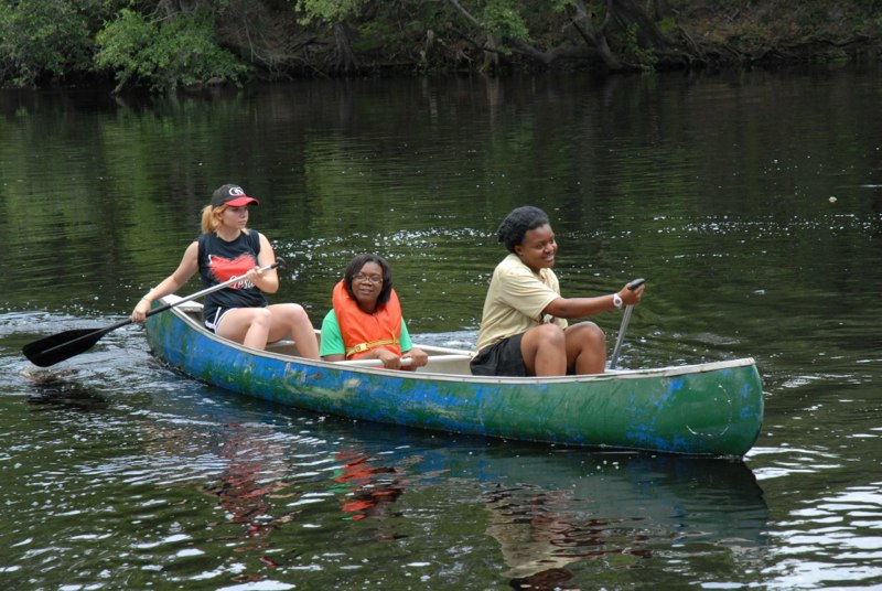 Campers paddling a canoe on the river