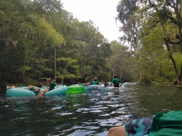 Group of campers floating on river tubes