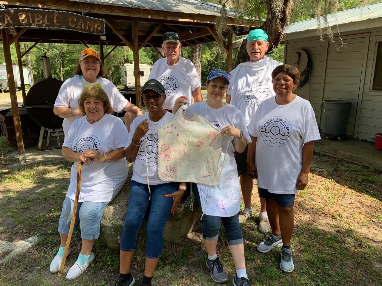 Camp volunteers with camper-signed keepsake