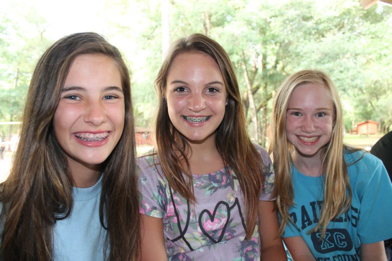 Three smiling girls enjoying time at camp