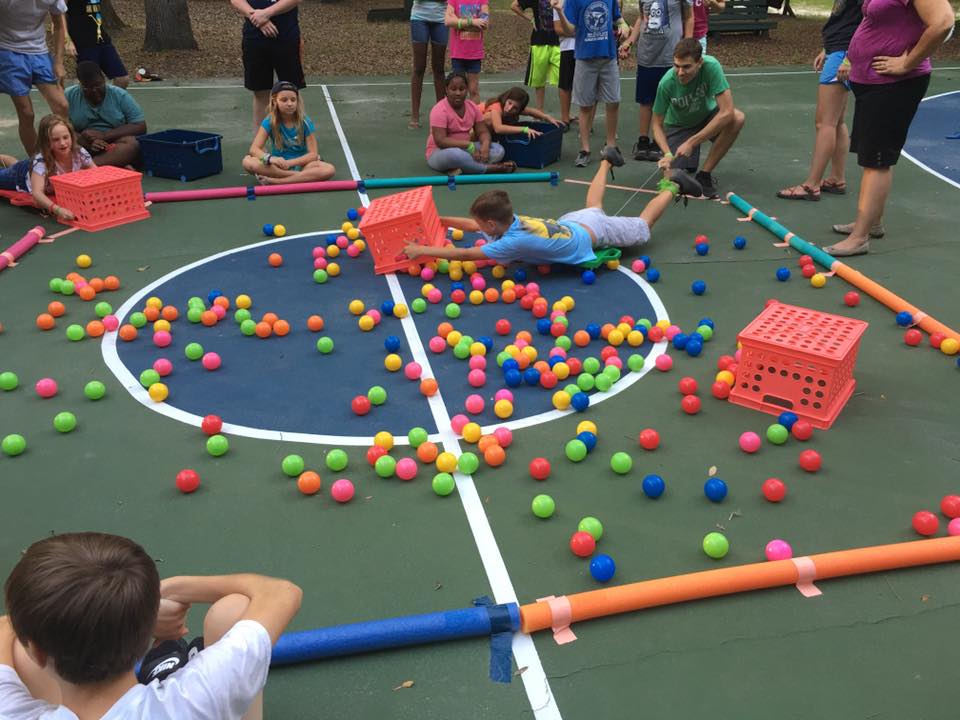 Camper diving for balls in outdoor game