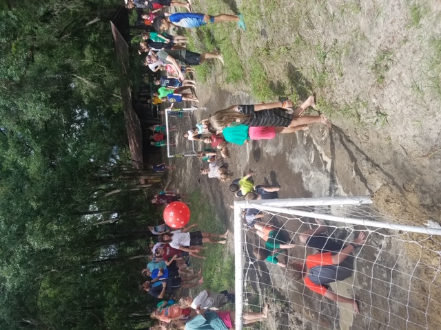 Campers playing muddy soccer with giant ball