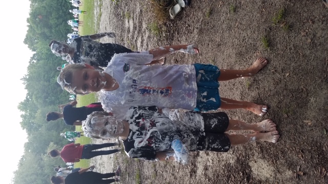 Two campers covered in shaving cream smiling